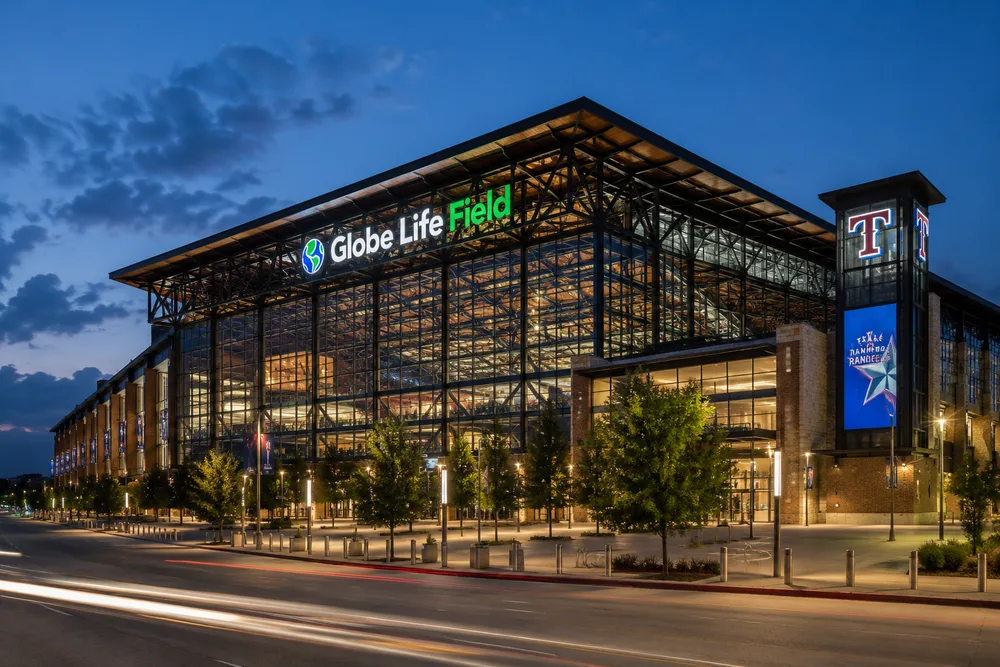 a large illuminated sports venue demonstrating complex structural and public-realm design.
