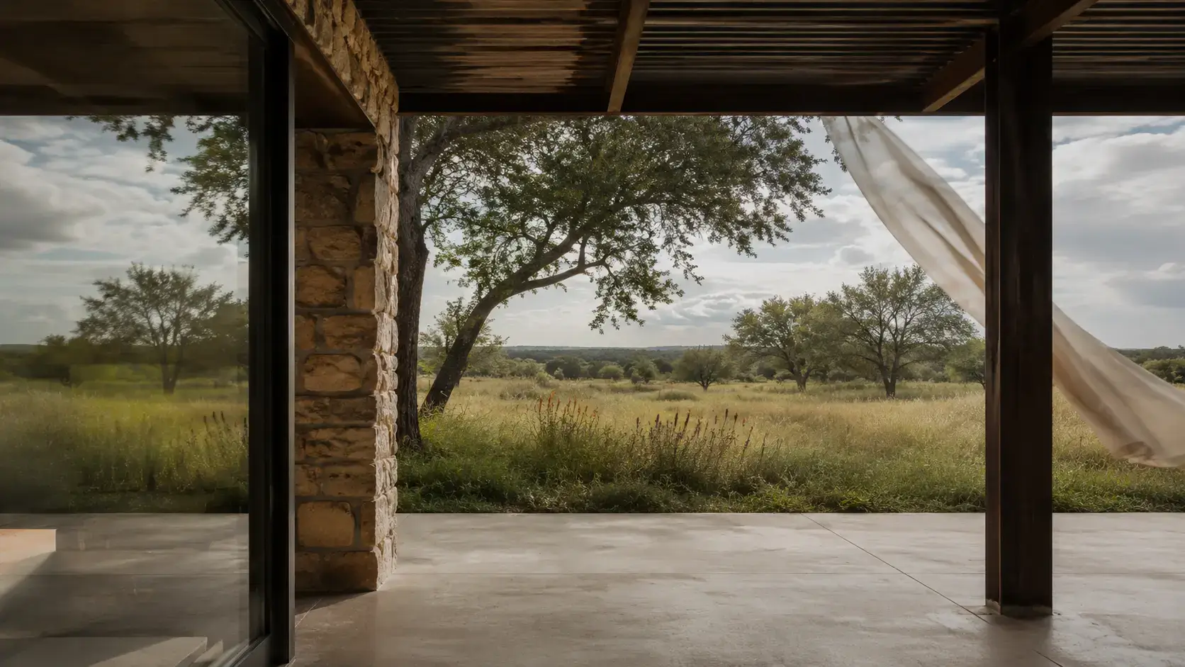 Shaded breezeway connecting a contemporary Texas house to native grasses and mature live oaks
