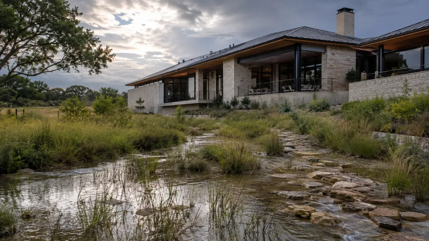 Rain garden and limestone drainage channel managing stormwater beside a Texas residence